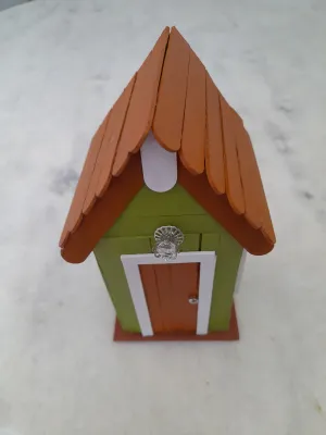 Mini casa decorado com palito e luminária no interior nas cores verde , branco e marrom