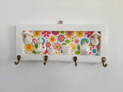 Porta chave de madeira branco fundo colorido decorado com aparelho de chá